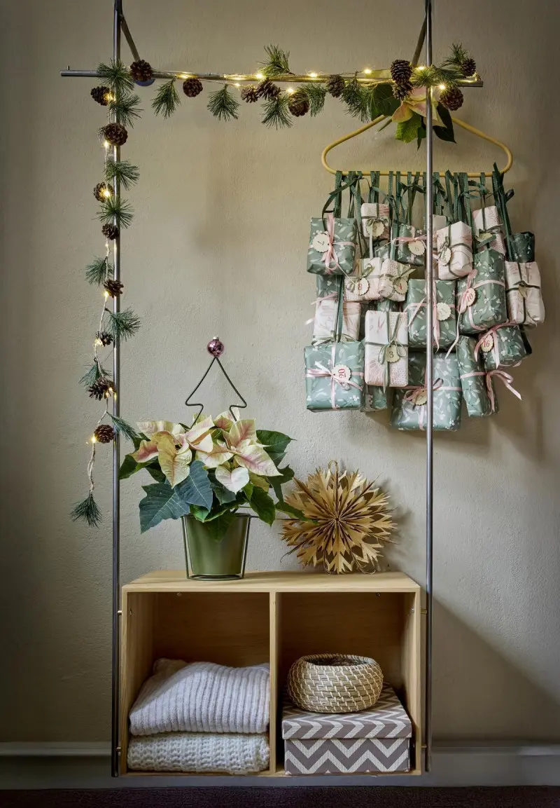 Świąteczna dekoracja wnętrza z kalendarzem adwentowym, poinsecją w doniczce i girlandą z szyszek