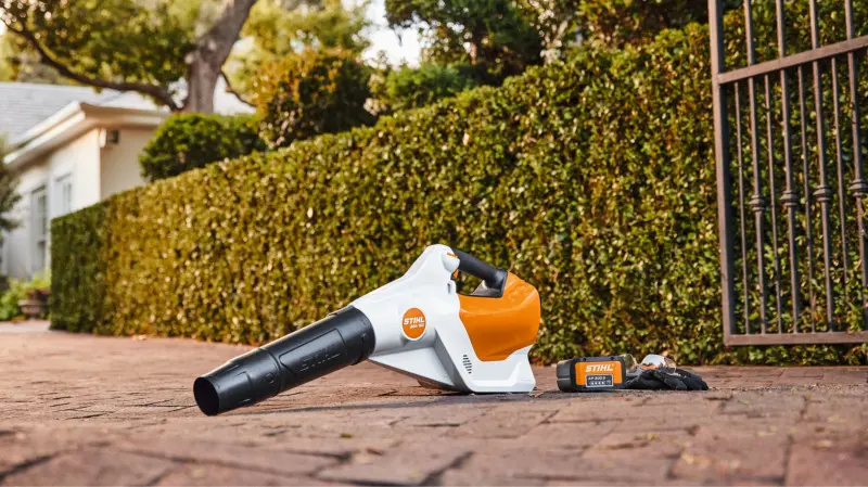 Akumulatorowa dmuchawa STIHL BGA 160 leżąca na podjeździe, gotowa do pracy z liśćmi.