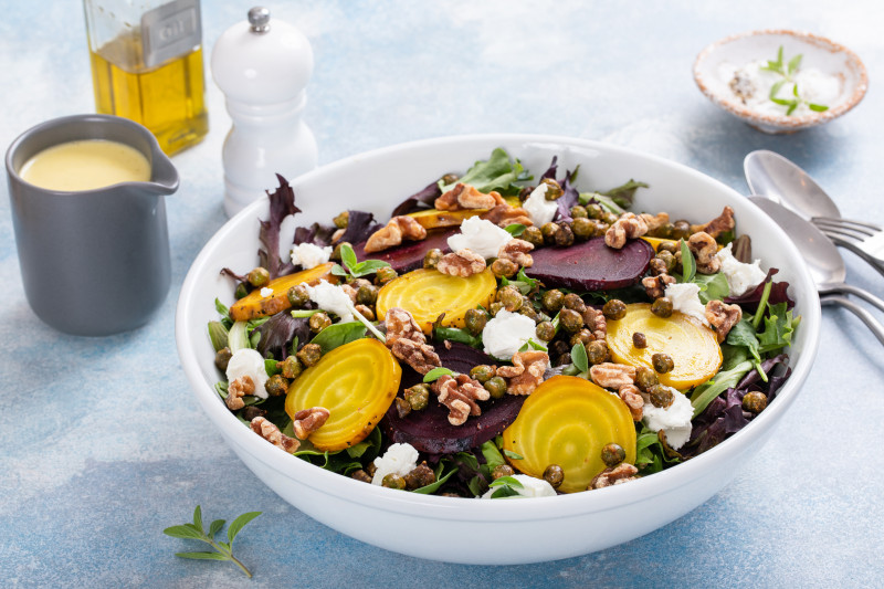 Sałatka z żółtymi i czerwonymi burakami, orzechami włoskimi, kaparami i kozim serem na miksie sałat
