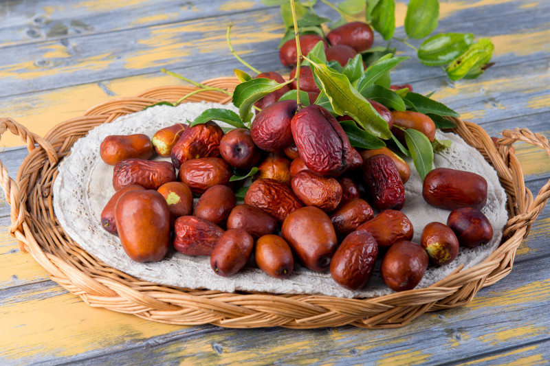 Owoce głożyny pospolitej (Ziziphus jujuba), czyli daktyle chińskie, zebrane w koszyku – świeże i podsuszone, o brązowej, lekko pomarszczonej skórce.