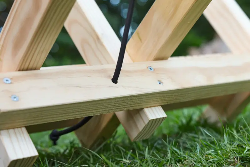 Krok 7. Przewlecz gumowy sznurek przez otwór, aby stabilnie przytrzymywać drewno.