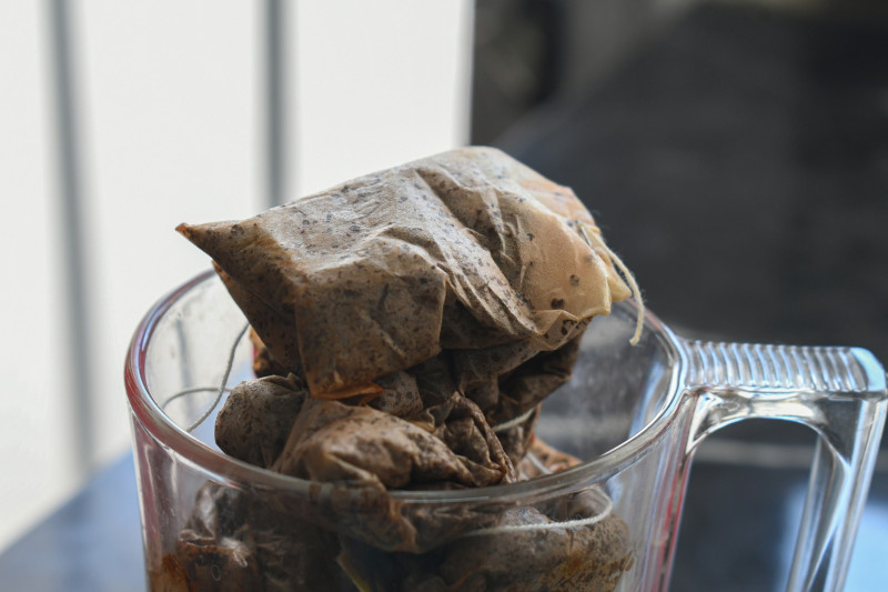 Mokre, zużyte torebki herbaty w szklanym kubku przed gotowaniem na domowy płyn do luster