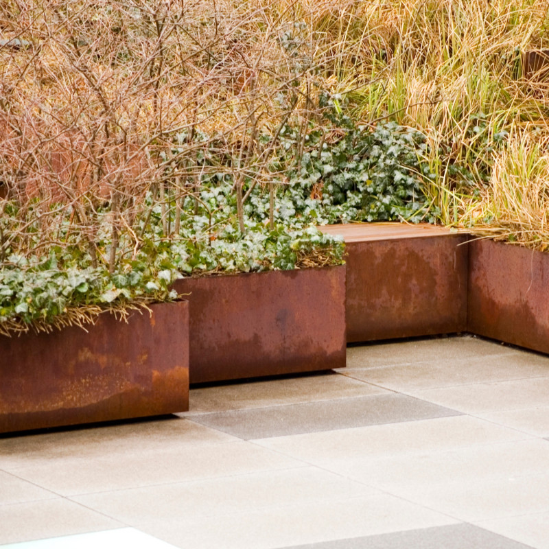 Zakątek ogrodowy z krzewami w donicach z cortenu