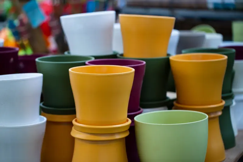 Kolorowe doniczki wielorazowego użytku ustawione w rzędach – nowoczesna alternatywa dla doniczek jednorazowych.